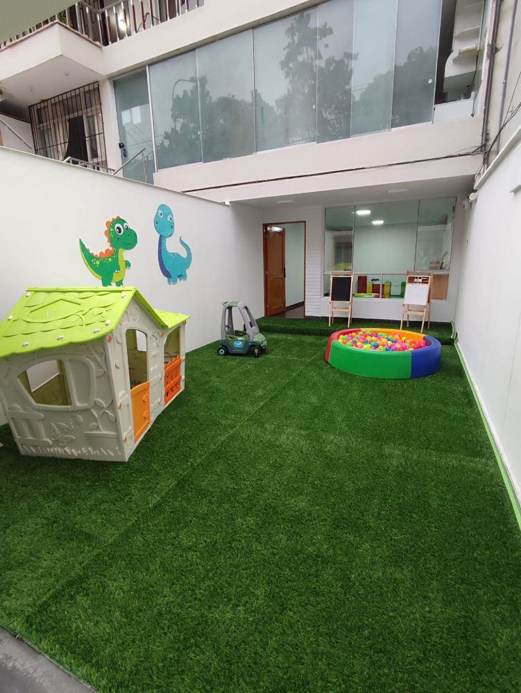 Patio del centro con casita de juegos, piscina de pelotas y pizarras