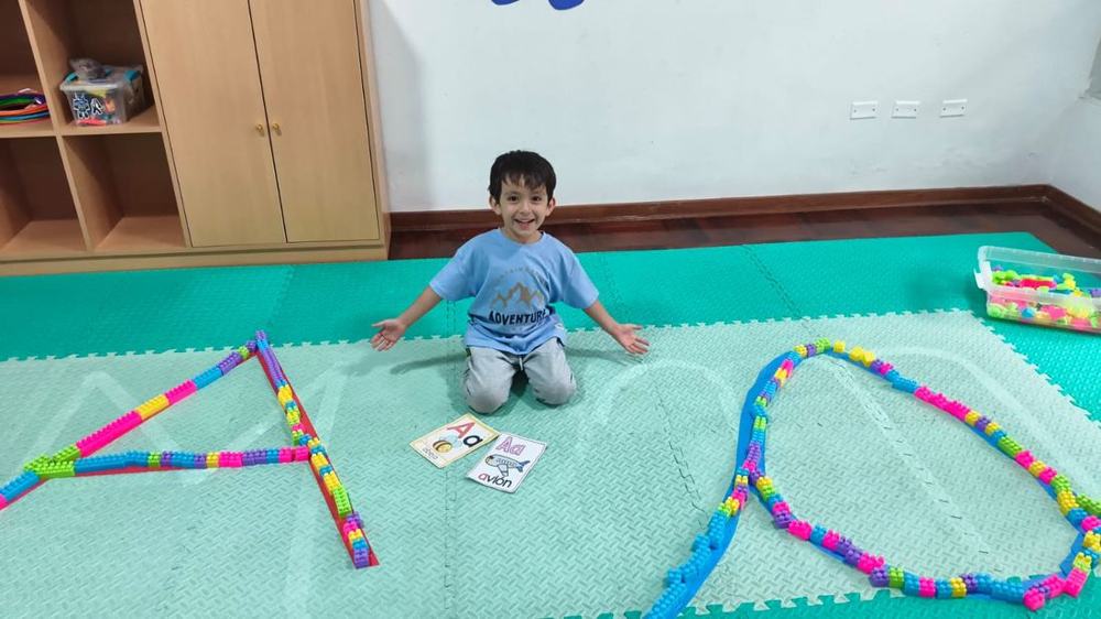Niño formando letras con bloques de construcción