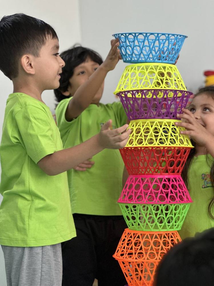 Niños apilando canastas de colores en clase