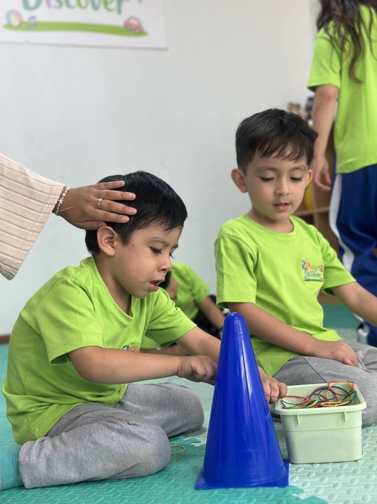 Niños trabajando la motricidad fina con conos y ligas