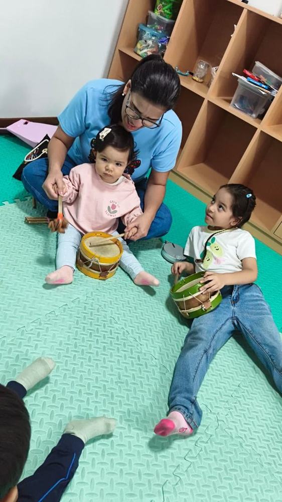 Miss enseñando musicoterapia con tambores