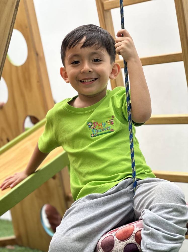 Niño sonriendo en el área de juegos de Play and Discover
